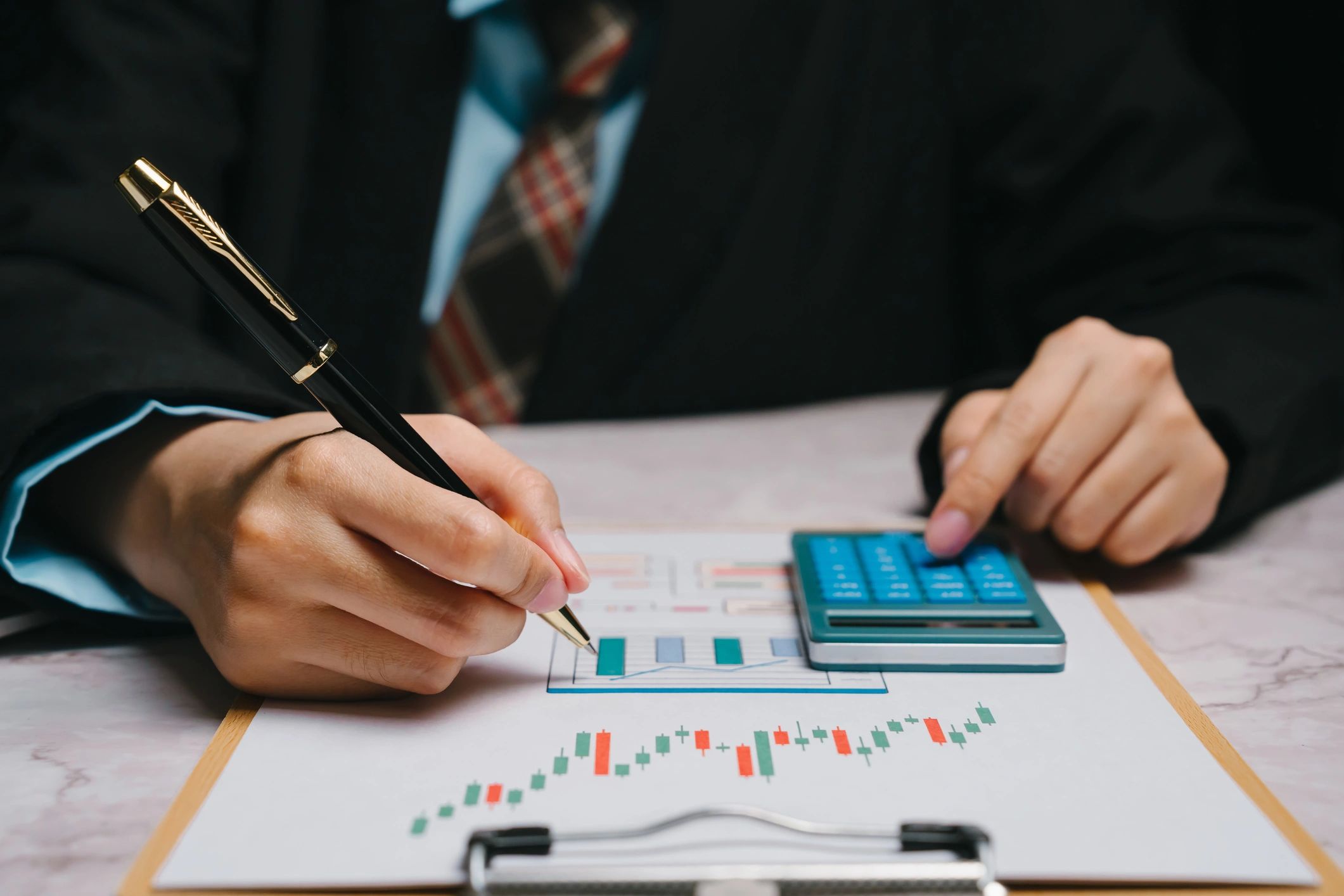 Analyst reviewing investment data with calculator and charts